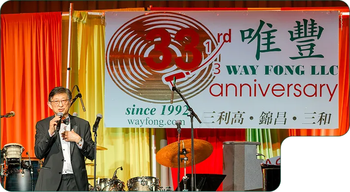 Way Fong Employees posing in front of the Way Fong Logo